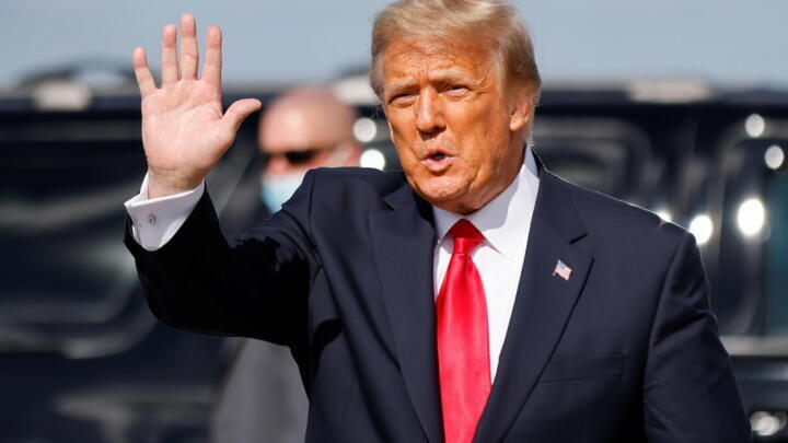Former US President Donald Trump waves as he arrives at Palm Beach International Airport in Florida on January 20, 2021.